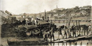 Гродзенскае “Эльдарада”: як хітры інжынер выцягнуў грошы з дна Нёмана і з дзяржаўнага бюджэту 1920, Гродна. Разбураны чыгуначны мост праз Нёман, знішчаны бронецягнік, на заднім плане драўляны мост, пабудаваны польскімі сапёрамі. Фота: Hrodna 11:27