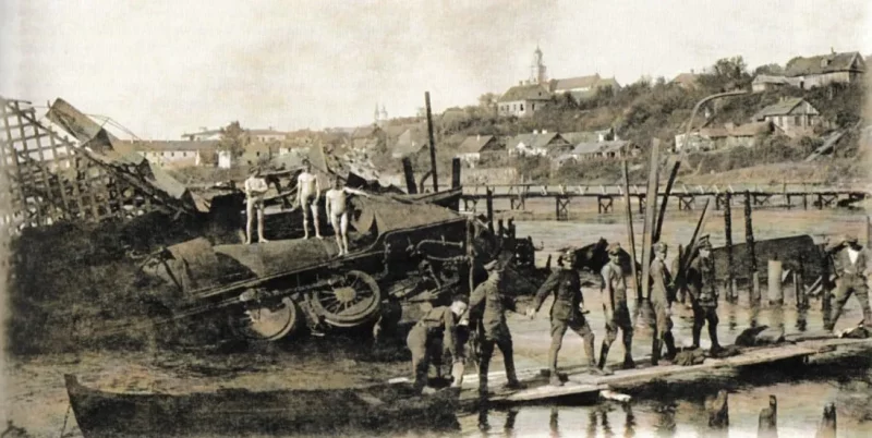 Гродзенскае “Эльдарада”: як хітры інжынер выцягнуў грошы з дна Нёмана і з дзяржаўнага бюджэту 1920, Гродна. Разбураны чыгуначны мост праз Нёман, знішчаны бронецягнік, на заднім плане драўляны мост, пабудаваны польскімі сапёрамі. Фота: Hrodna 11:27